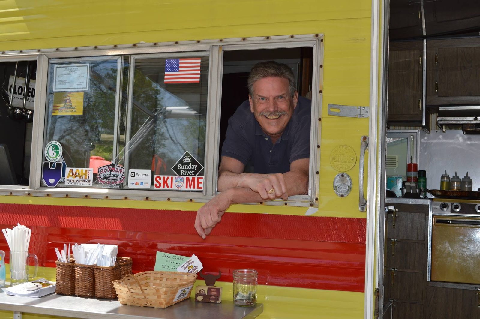 The full service window at Rocket Ron's, with the stainless counter, straws, condiments and Ron leaning out to talk